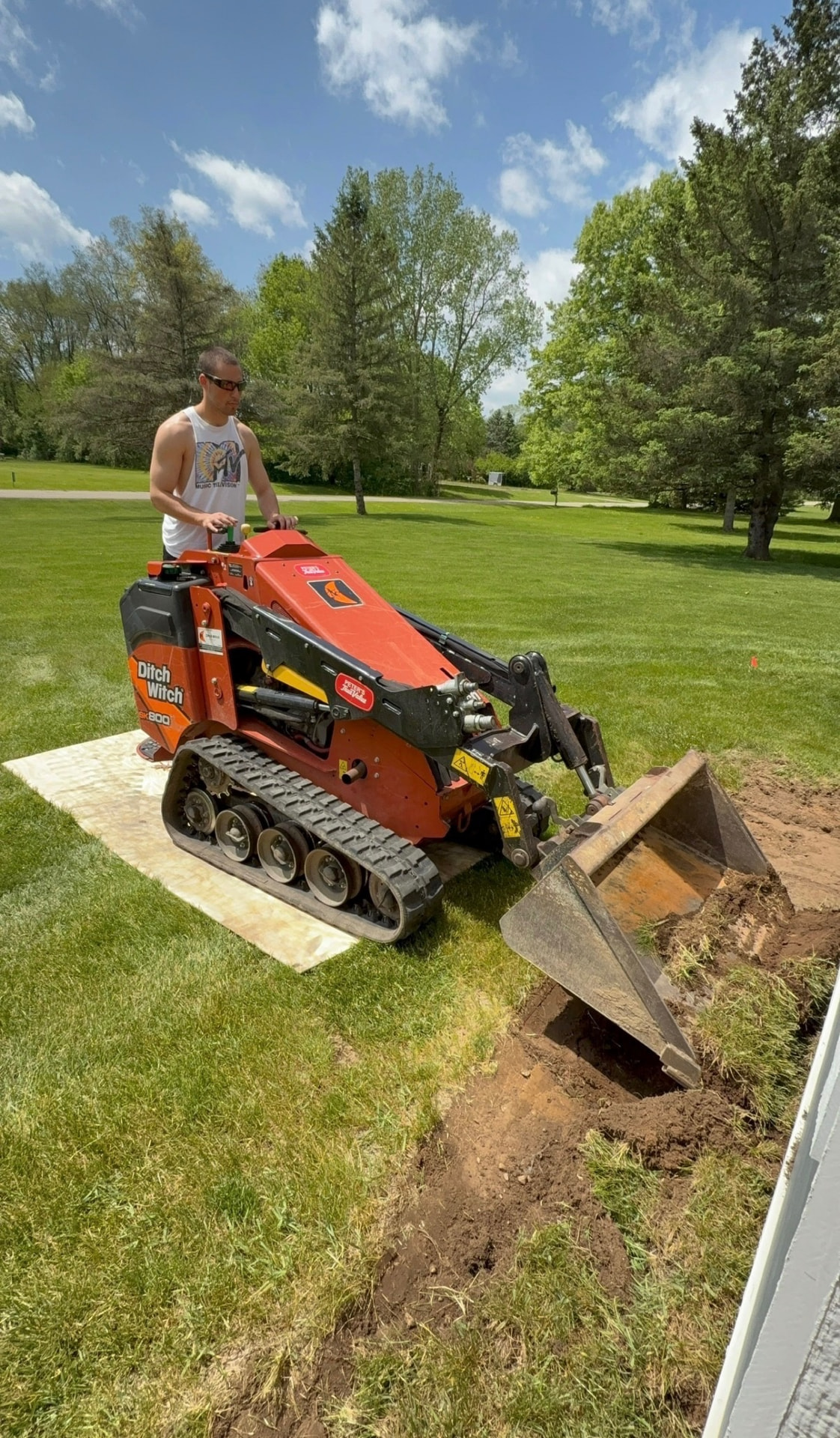 Traub crew member operating a mini skid steer to remove soil on a residential project